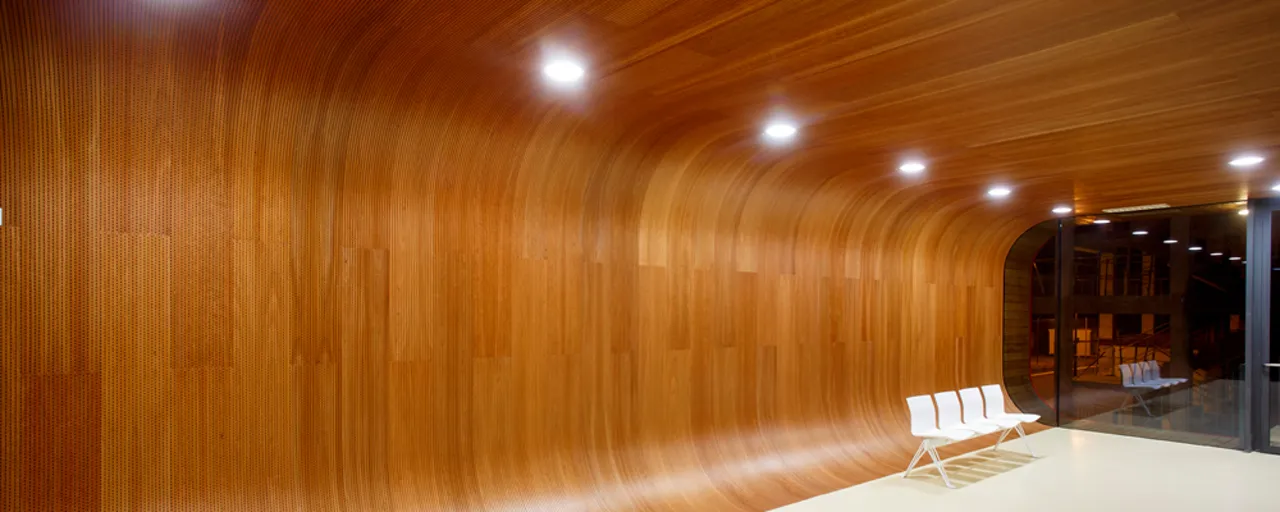 Revestimento curvo executado com compensado flexível Viroflex em ambiente interno.